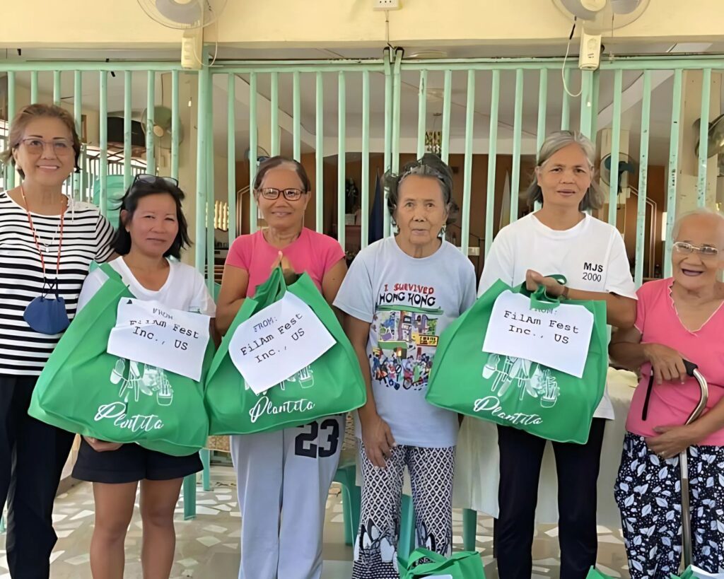 Volunteers from Fil-Am FEST Inc. distributing food and essential supplies to families in need during a community outreach and charity program.