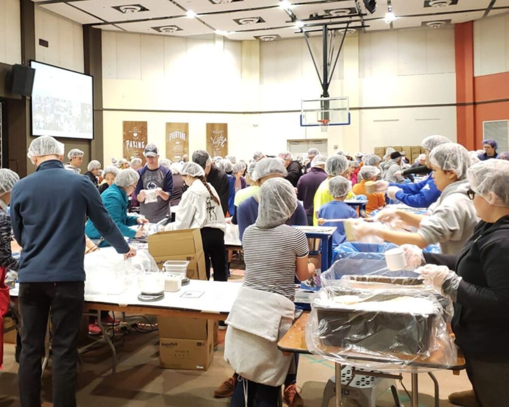 Volunteers at a Fil-Am FEST Inc. meal packing event, assembling food packages for families in need. A community-driven initiative to fight hunger and support humanitarian efforts.
